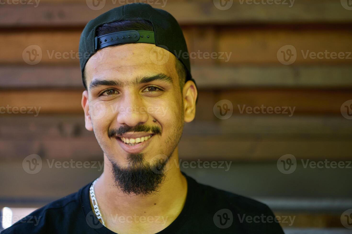 Close Up Portrait of Smiling Sudanese Teenager with Broad Smile, Chin, and Cap photo