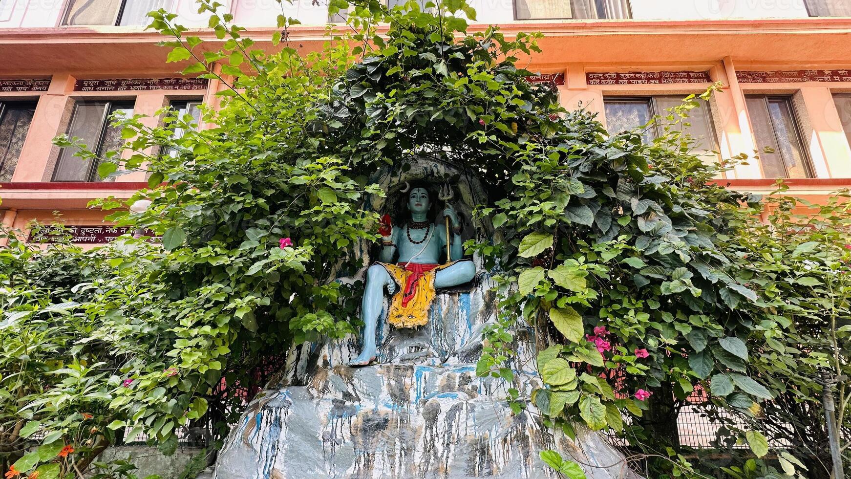 hindu god mahadev statue sitting in cave with trishul photo