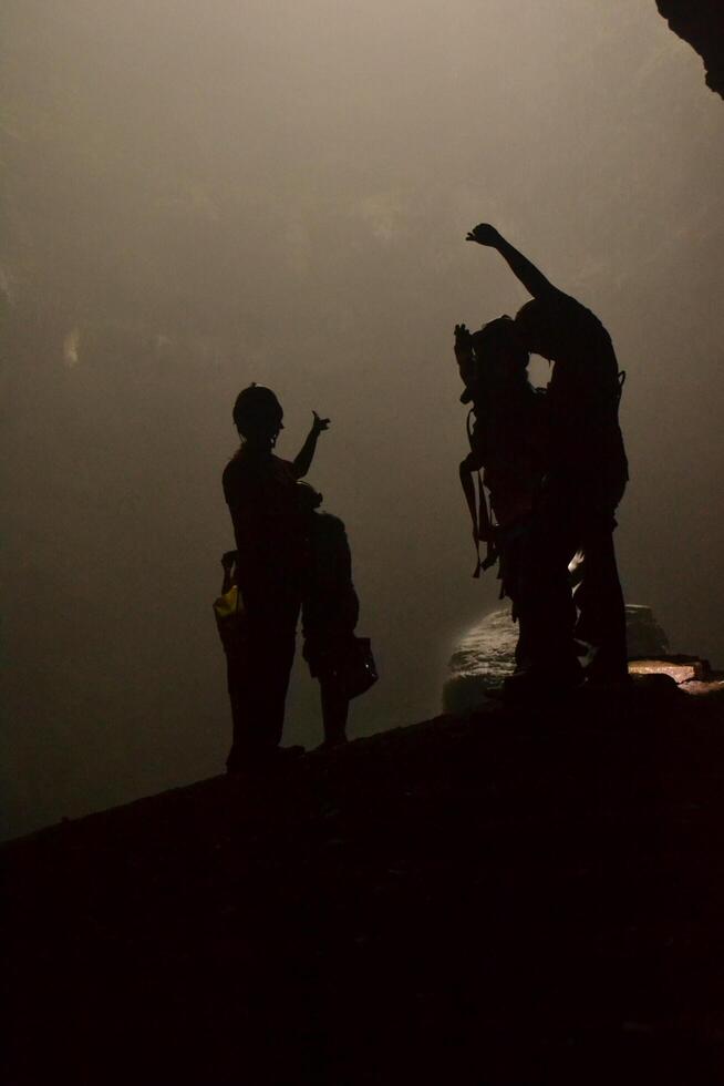 Silhouette of three people in Grubug vertical cave photo