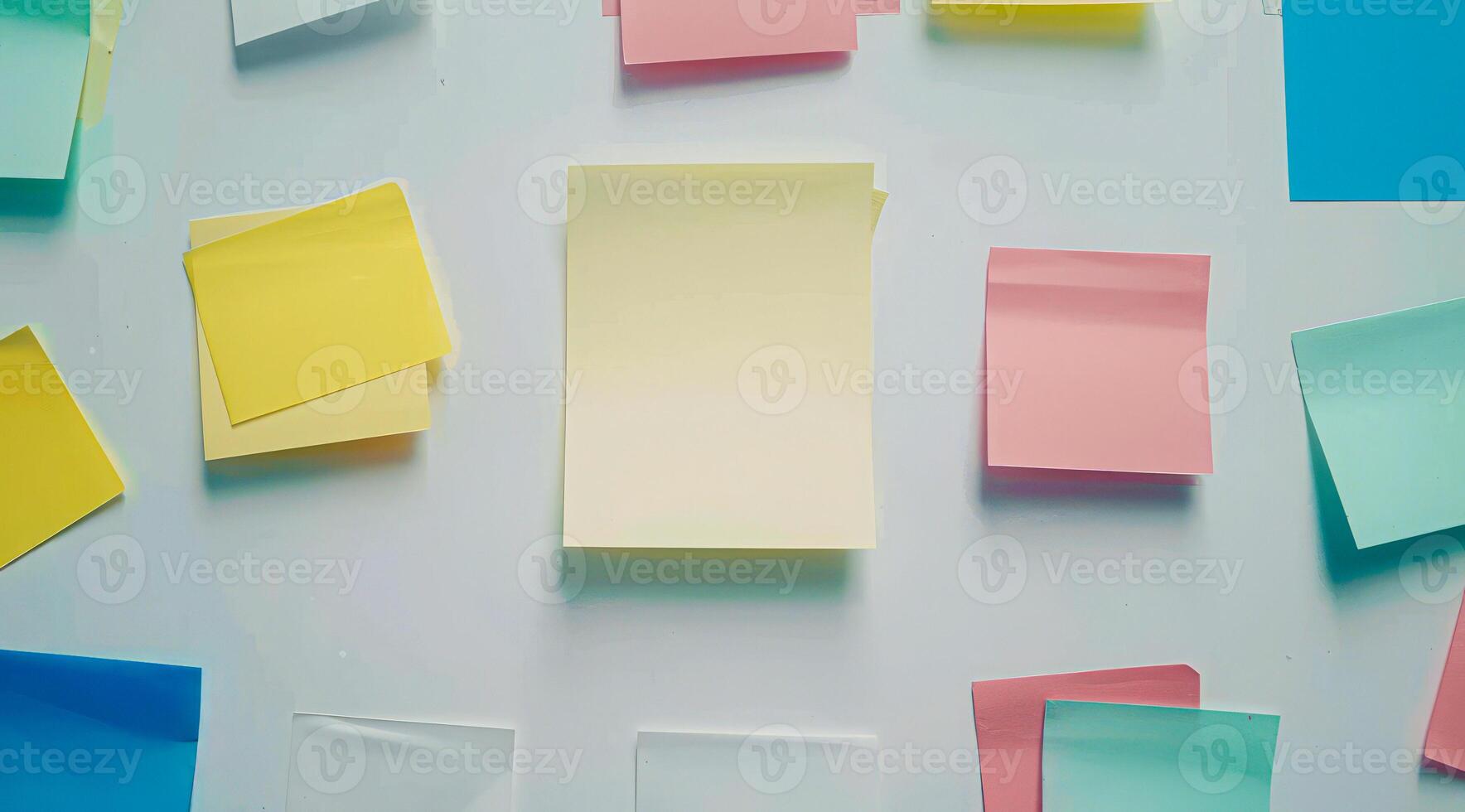 Three colourful post-it sticky notes are hanging on a white wall ...