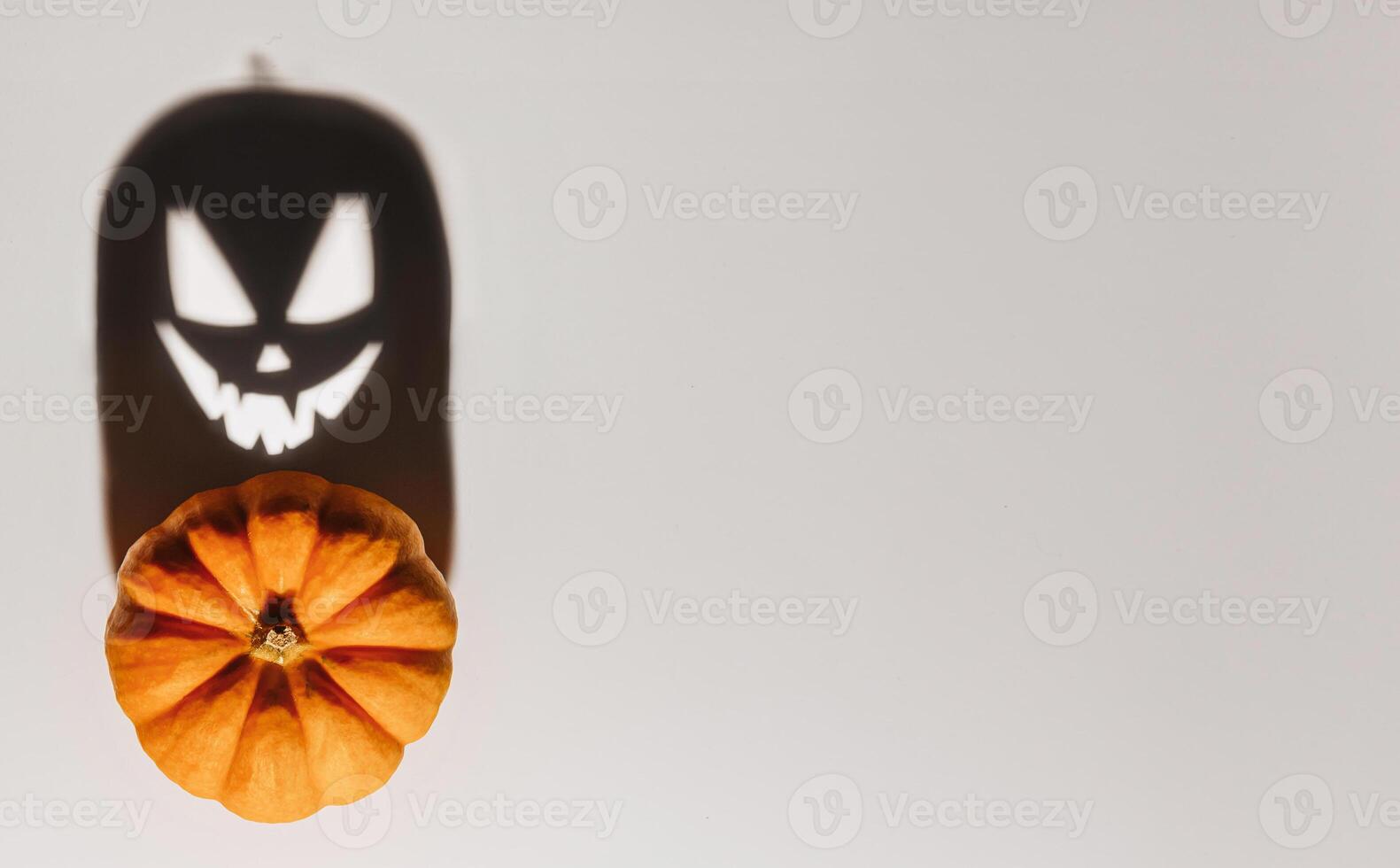 Halloween background concept. Jack O pumpkin angry face shadow. Spooky smiling shadow of an orange pumpkin lantern top view close up, Halloween party design photo