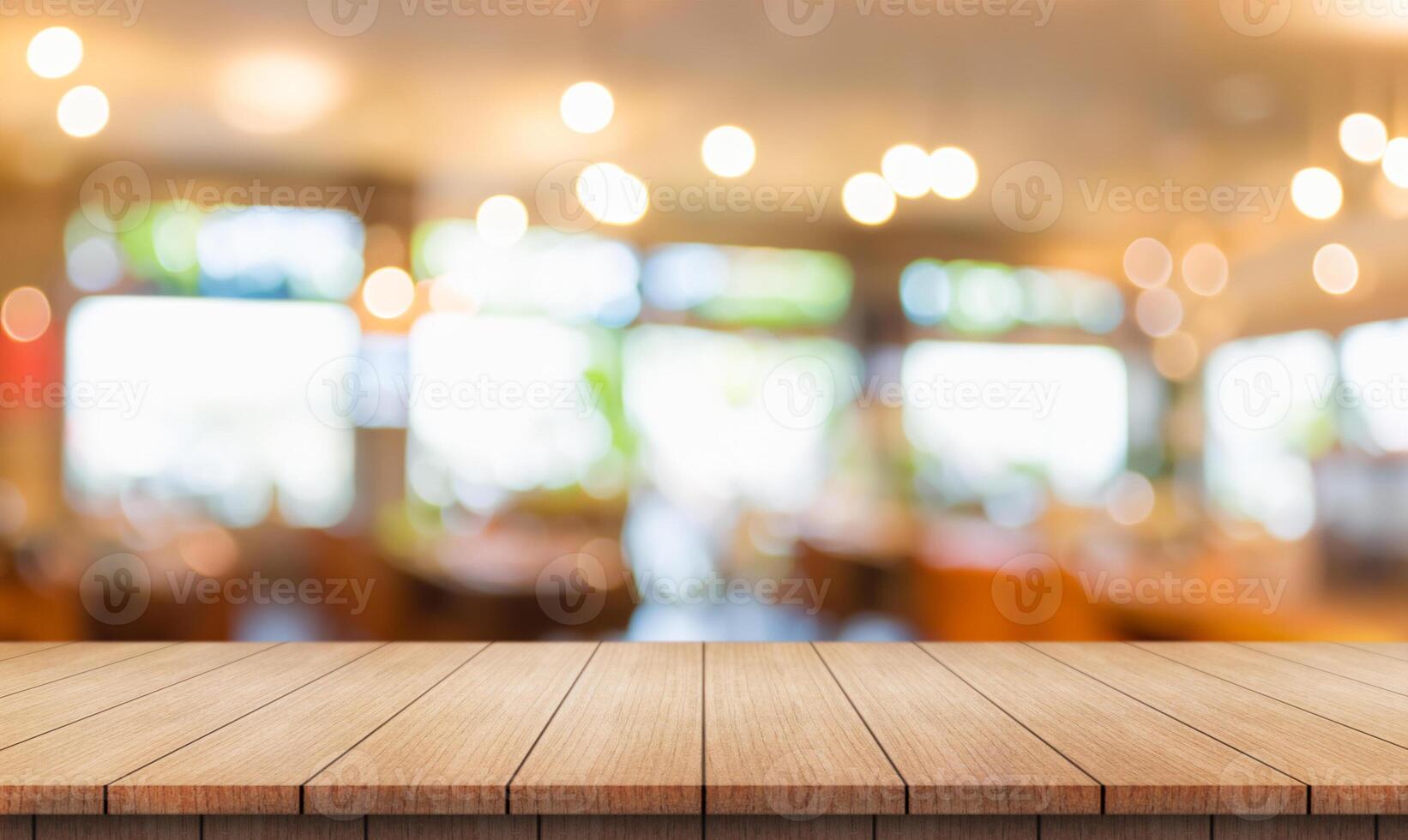 Empty wooden table top with lights bokeh on blur restaurant background. photo