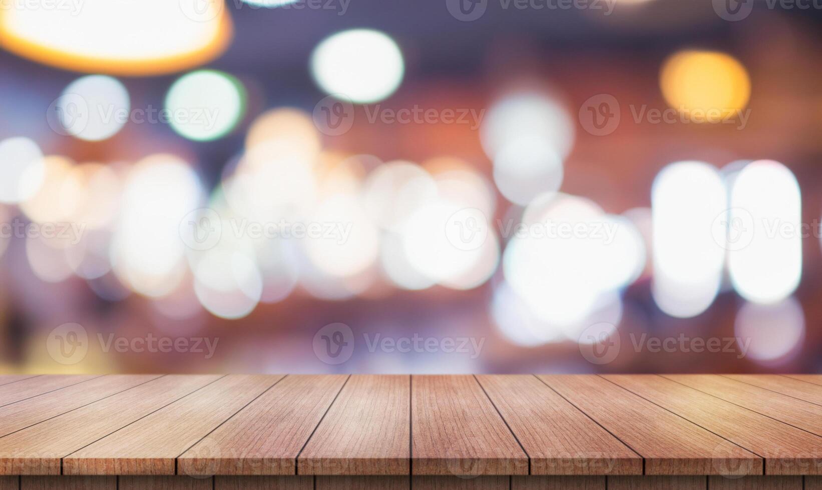 Empty wooden table top with lights bokeh on blur restaurant background. photo