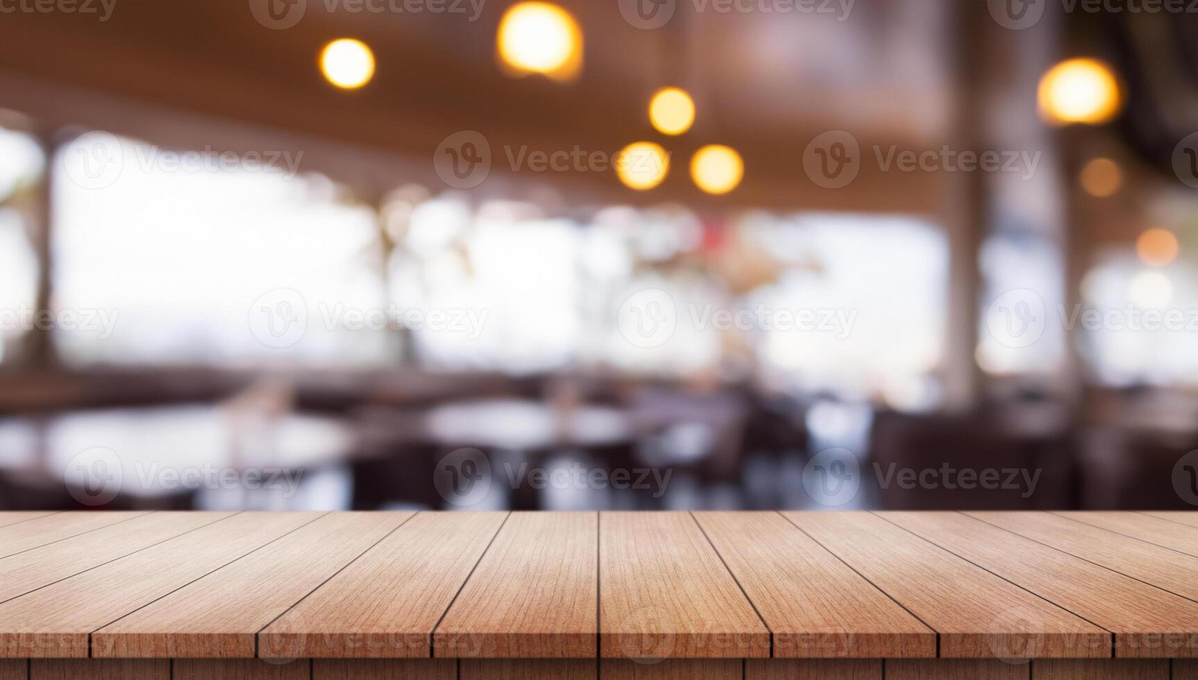 Empty wooden table top with lights bokeh on blur restaurant background. photo