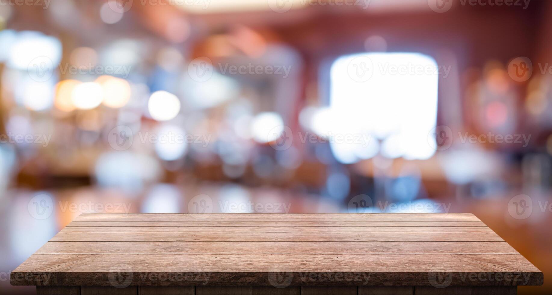 Empty wooden table top with lights bokeh on blur restaurant background photo