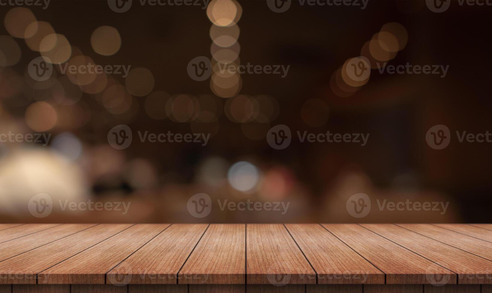 Empty wooden table top with lights bokeh on blur restaurant background photo