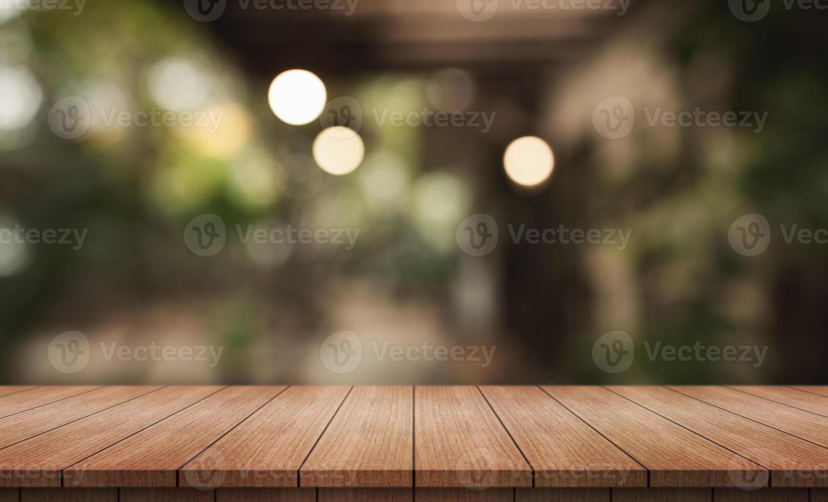 Empty wooden table top with lights bokeh on blur restaurant background. photo