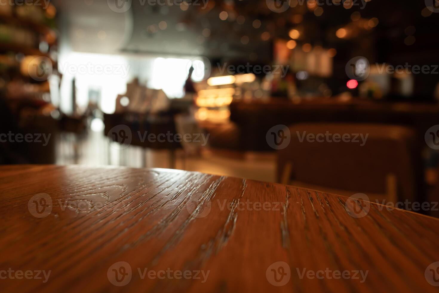 Empty wooden table top with lights bokeh on blur restaurant background photo