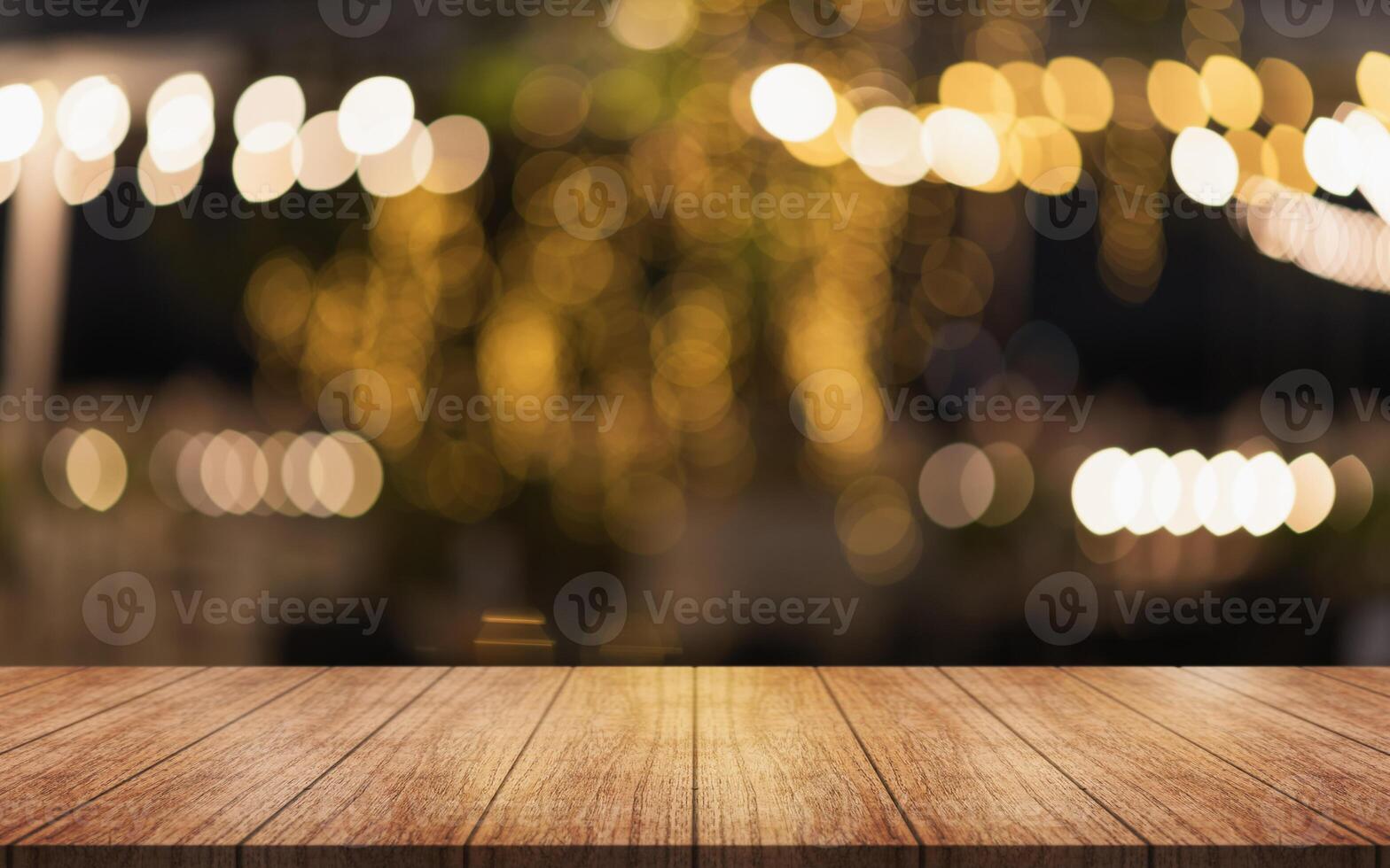 Empty wooden table top with lights bokeh on blur restaurant background. photo