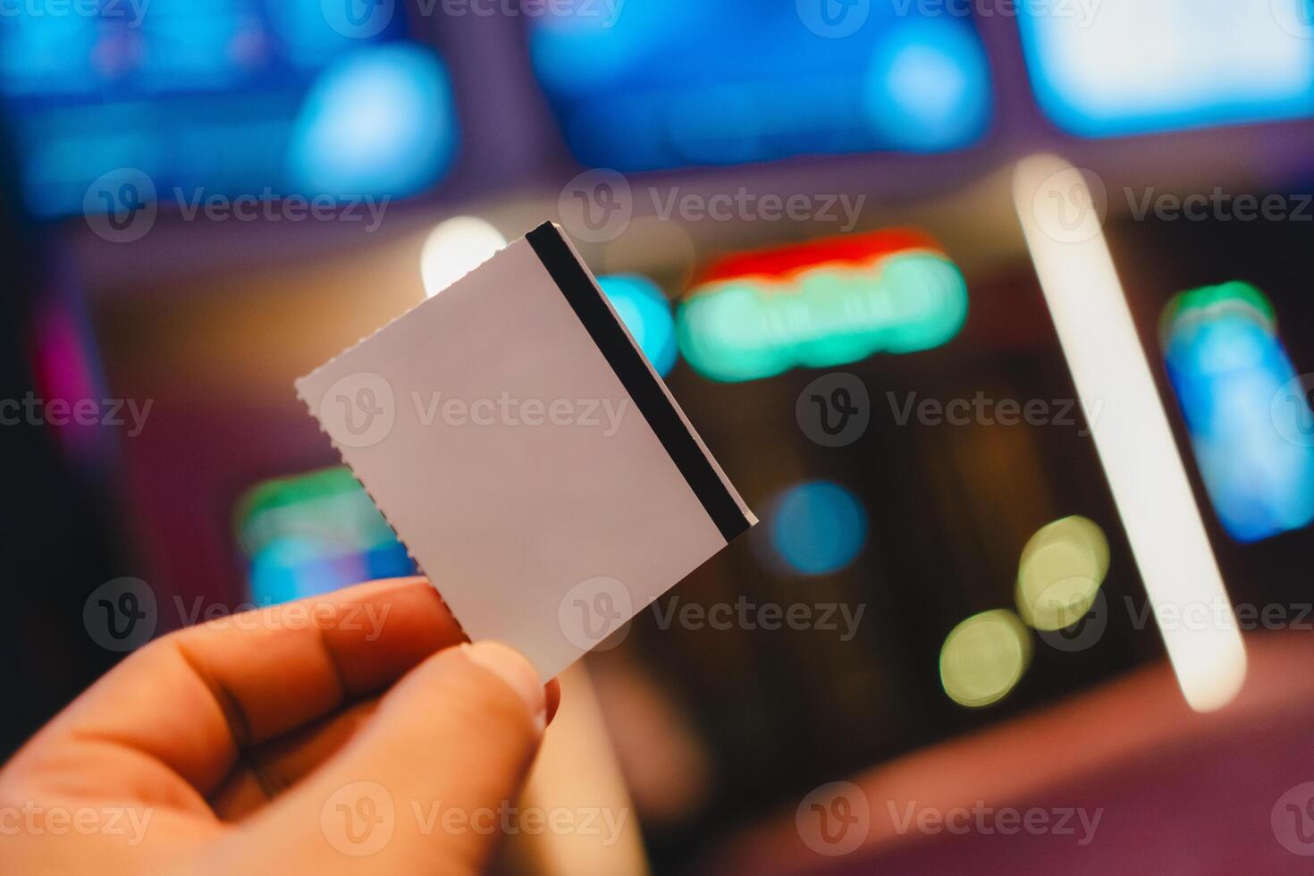 An unrecognizable person holding up a movie ticket. photo