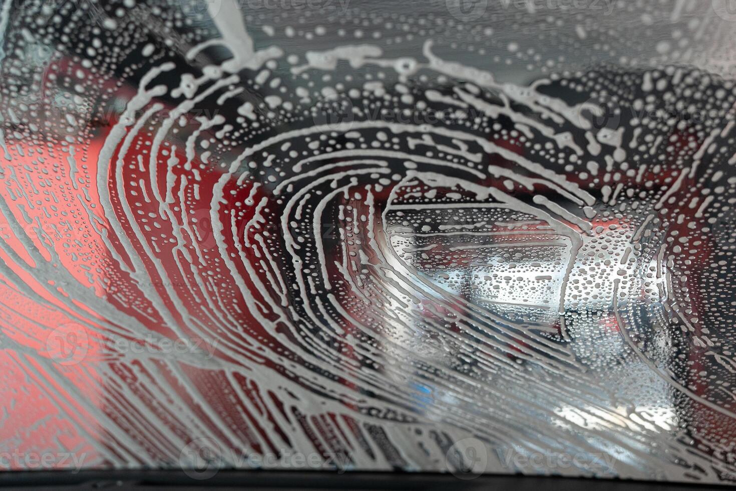 Car windows with white soapy foam during washing car. photo