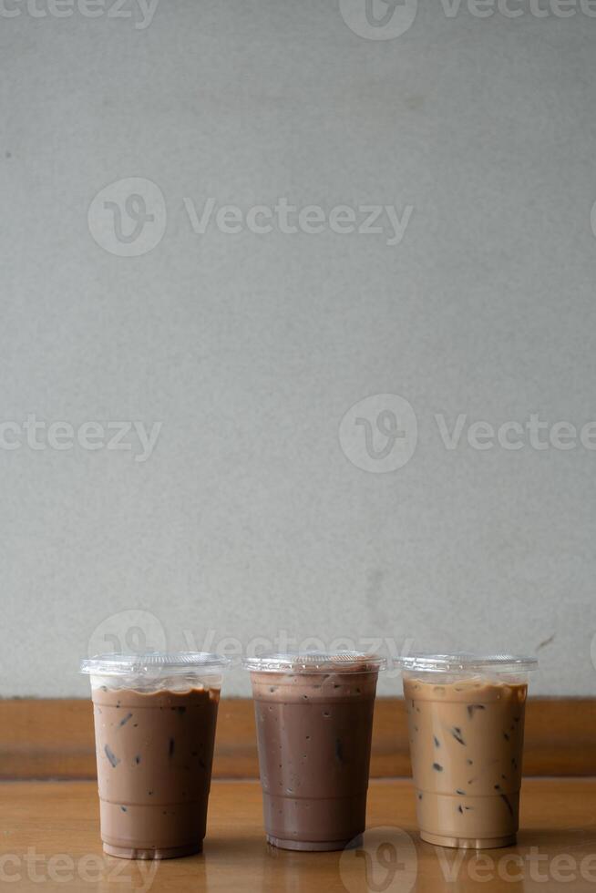 Take away plastic cup of iced chocolate, iced mocha and iced latte on table photo