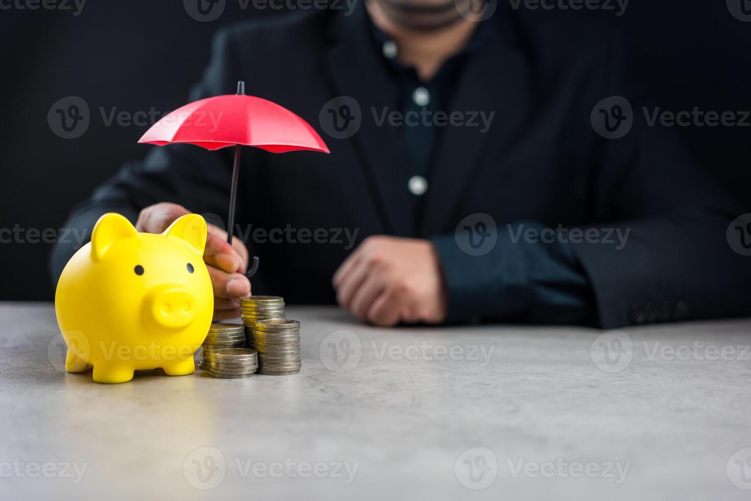 Businessman hand holding umbrella over coin stack and piggy bank. Financial Insurance, Protection photo
