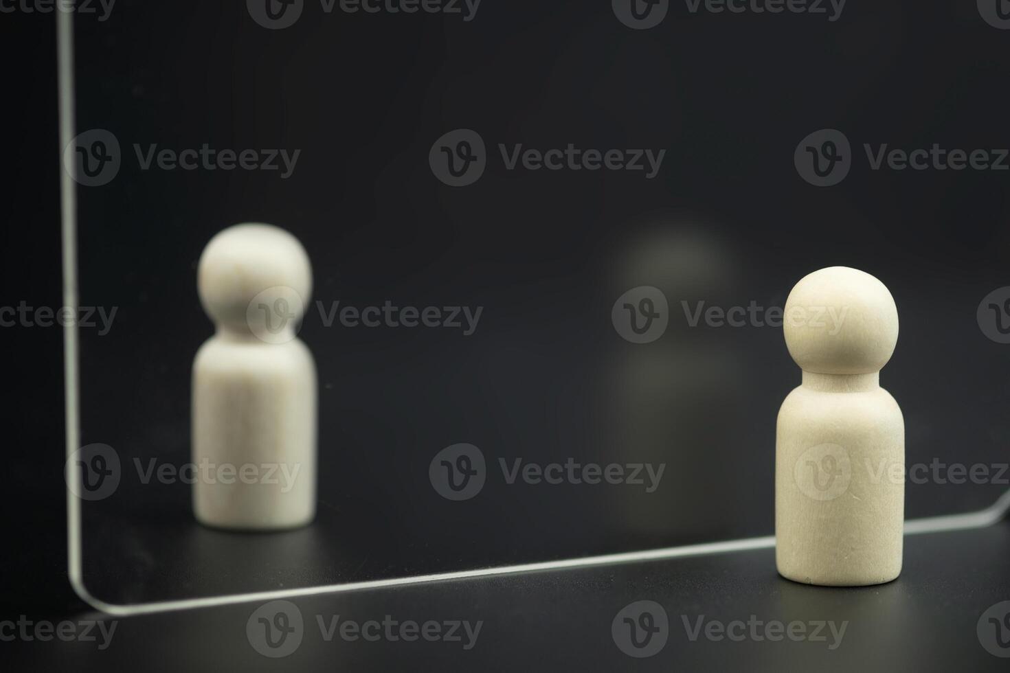 Wooden peg dolls standing stand looking through transparent glass. Reflections on prospects. photo