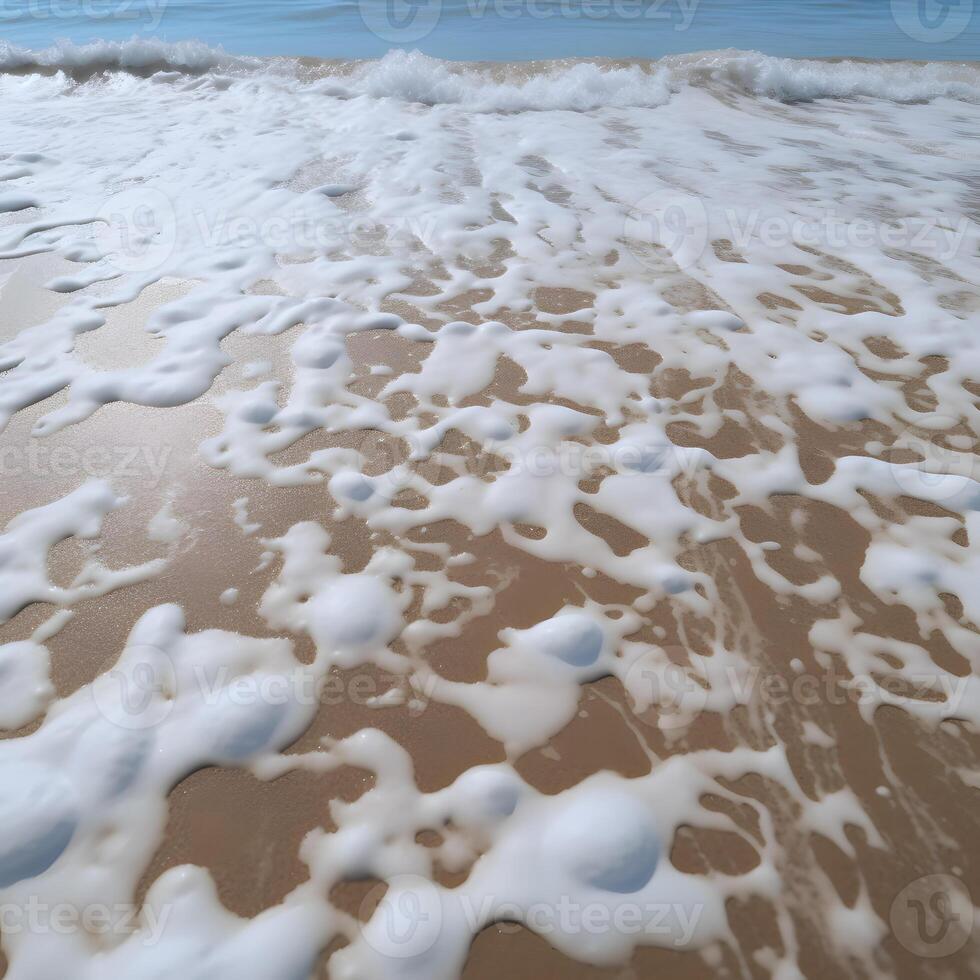 Sandy beach washed by sea water with foam photo