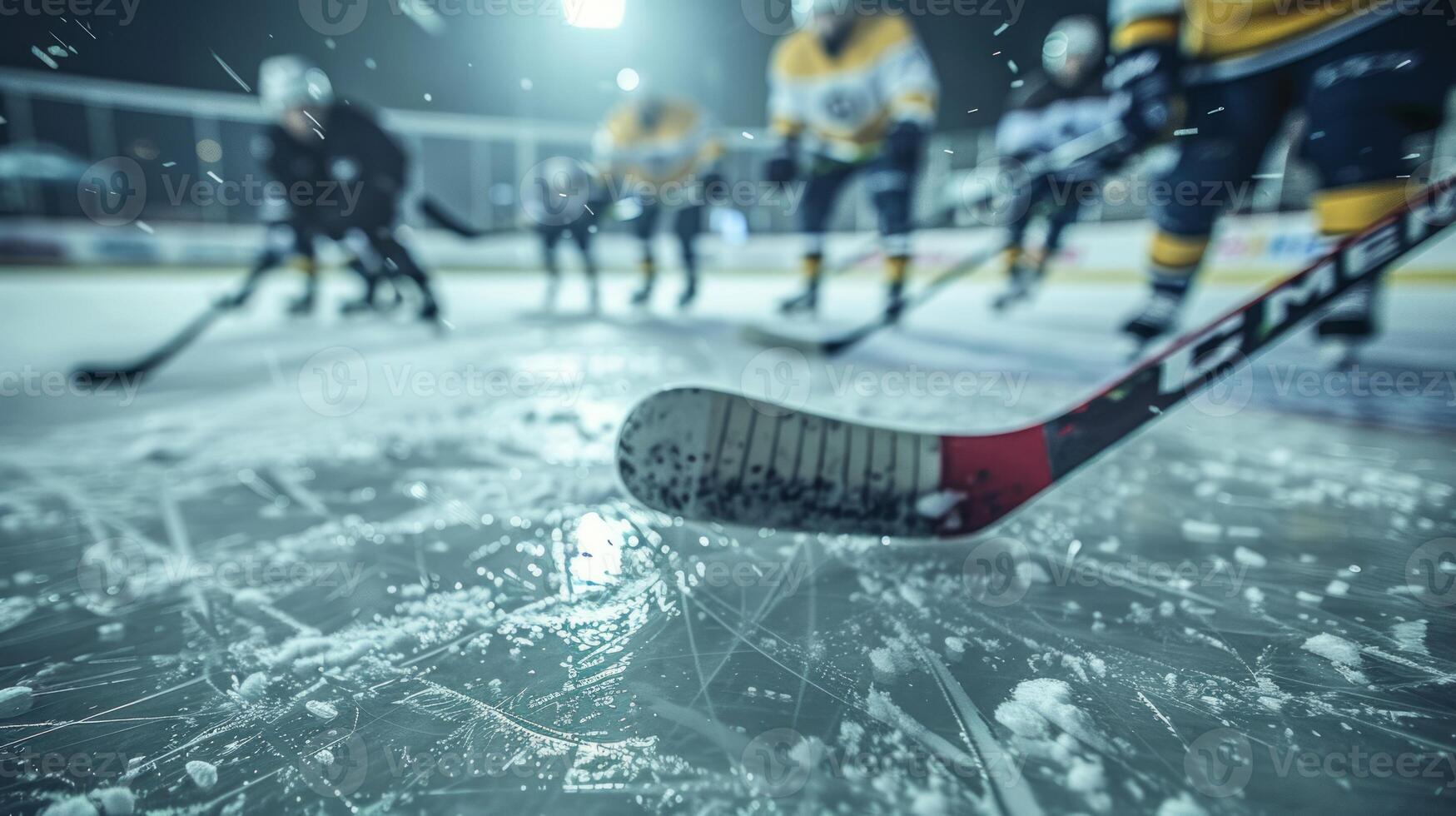 Close-up of hockey stick on ice with players in background. photo