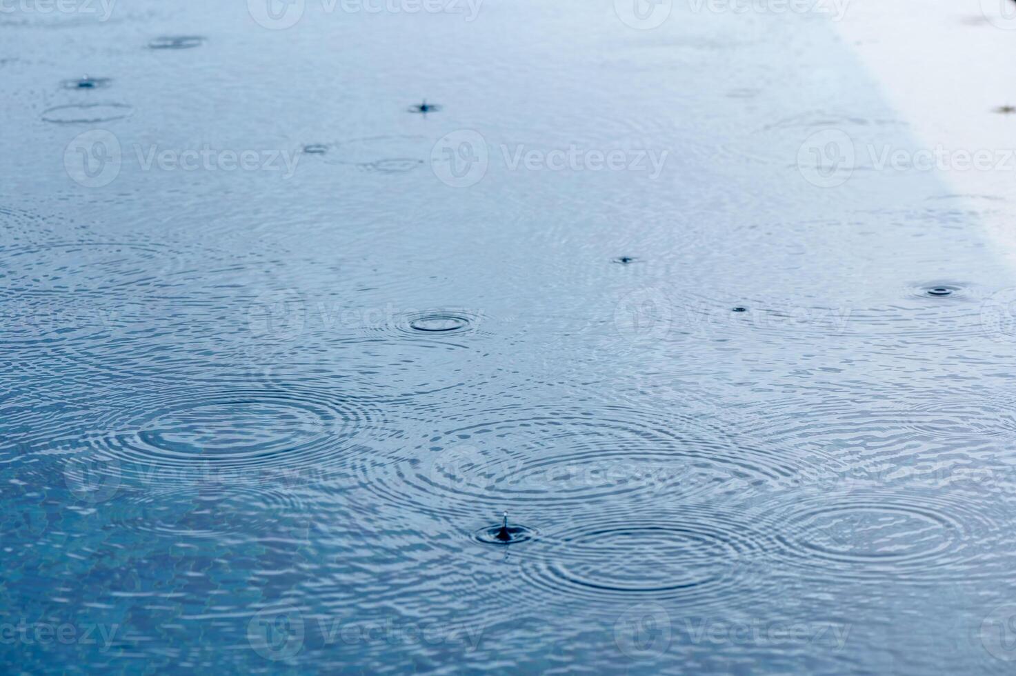 Round droplets of water over circles on pool water. 4 photo
