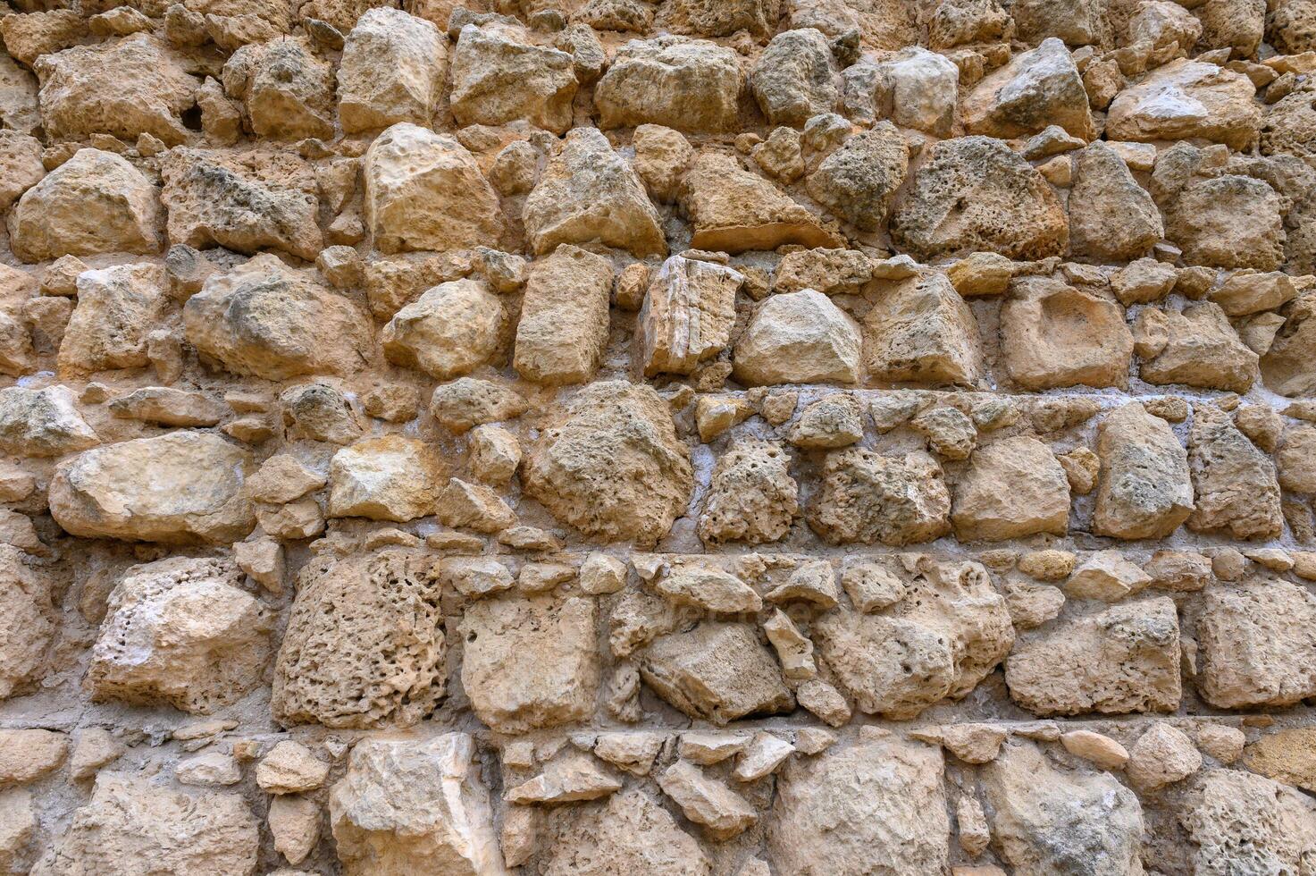 Texture of an ancient brick wall made of sandstone. Archaeological excavations photo
