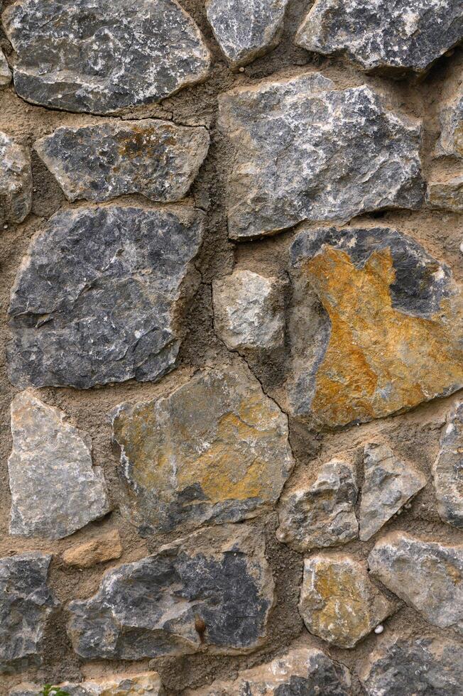 Stone wall as a background or texture. Part of a stone wall, for background or texture photo
