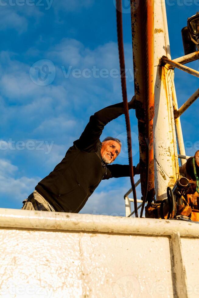 Middle-aged man playing captain on a boat stranded on an Icelandic beach photo