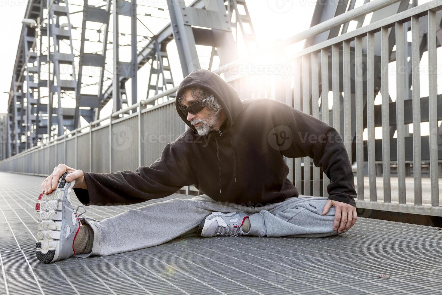 athlete doing stretching on metal bridge. Healthy lifestyle and sport concept photo