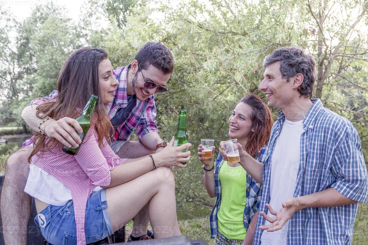 Happy group of young friends toasting with beer photo