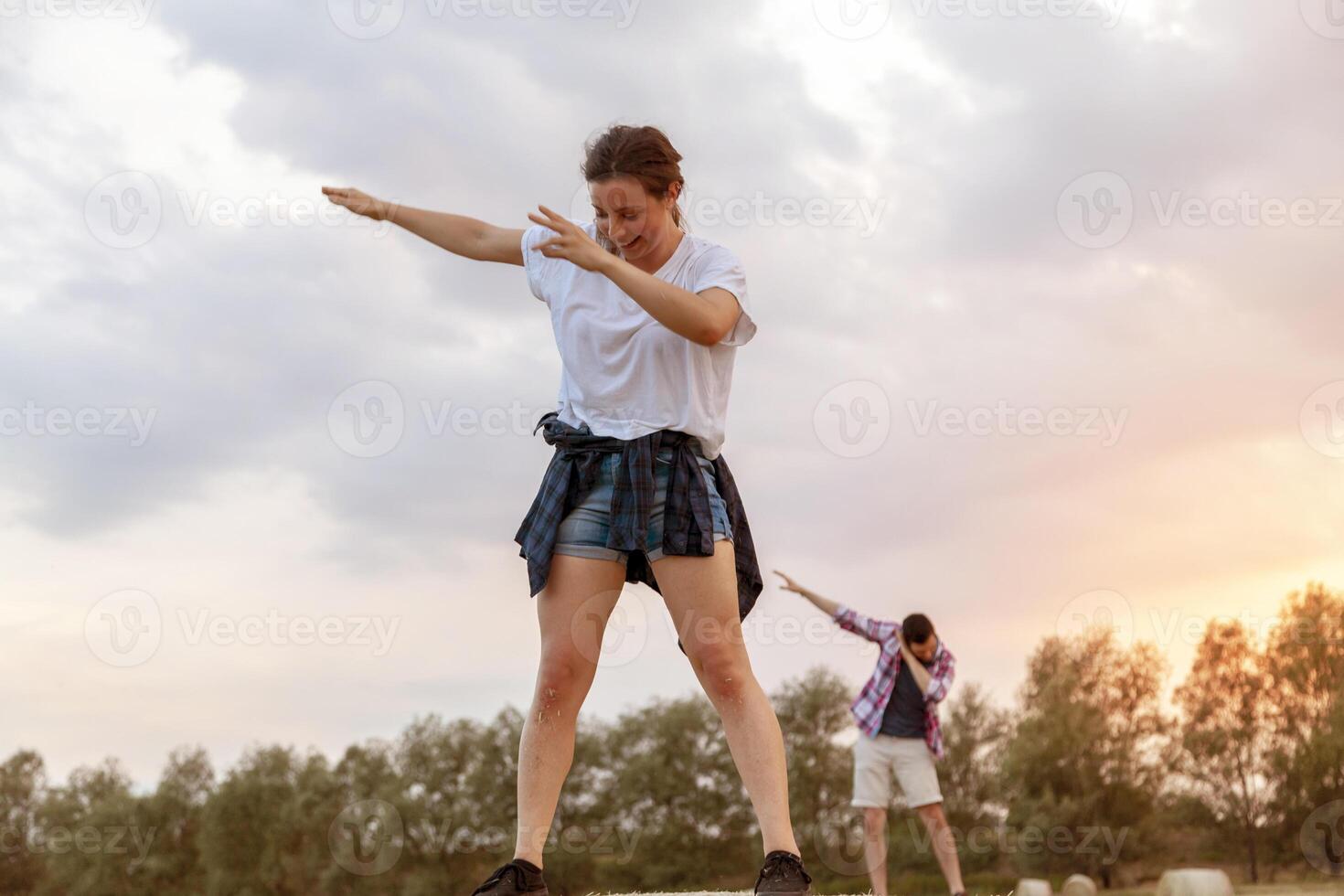 young millennial couple are doing synchronized gymnastics on the sheaves photo