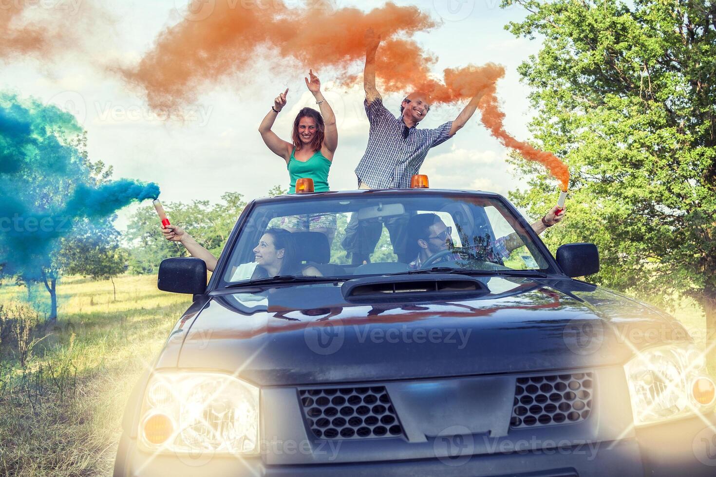 Group of young guys have fun with colored smoke trails photo
