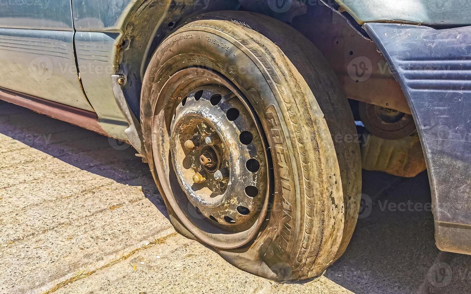 Flat rusted old tire on the car Puerto Escondido Mexico. photo