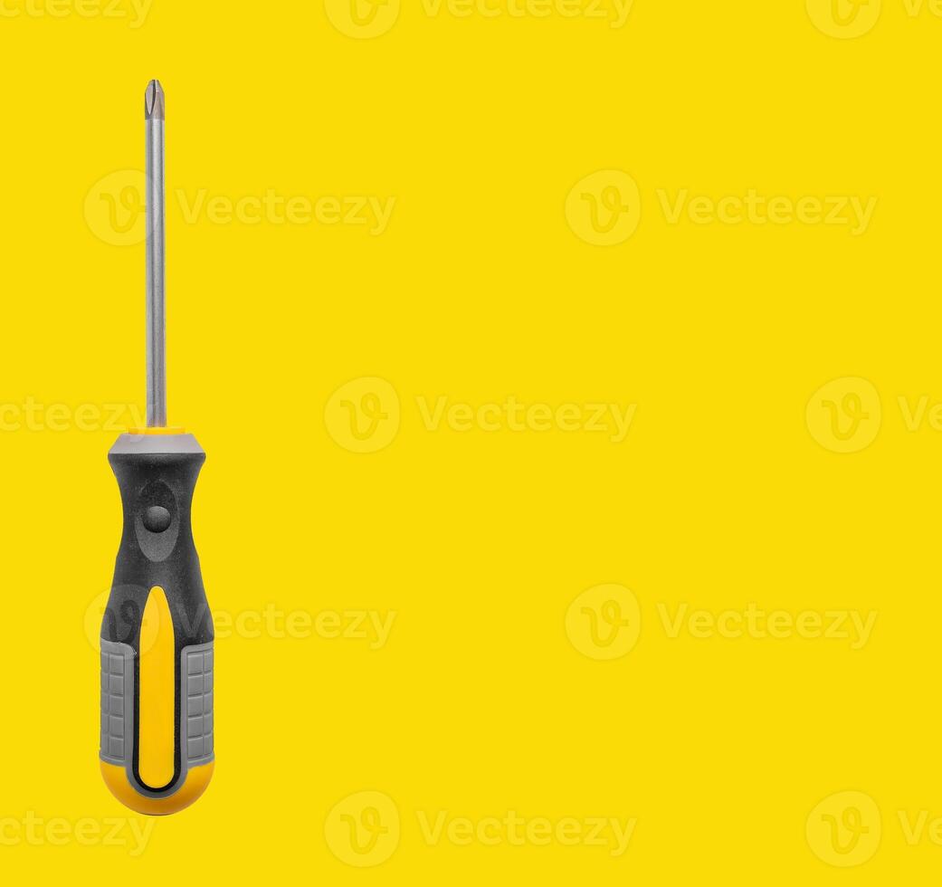 Screwdriver tool in hand, long handle and head for screw driving. Yellow background with promotional photo