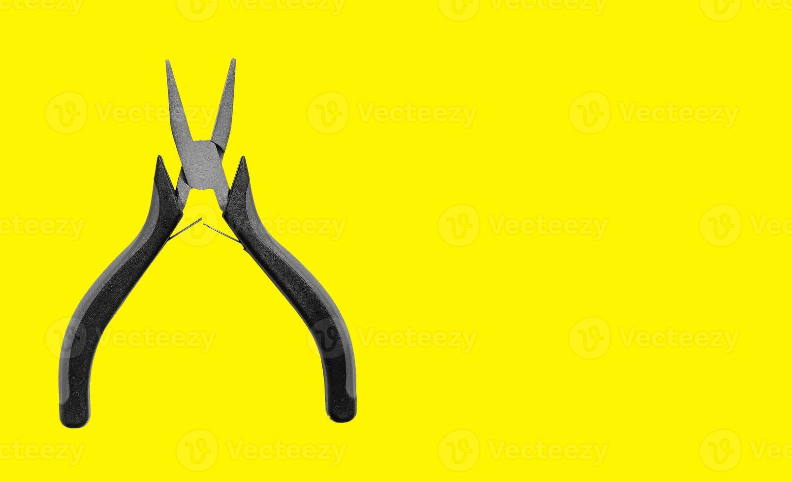 Long needle nose pliers, red grip tool for wire cutting. Industrial mechanic equipment on yellow photo