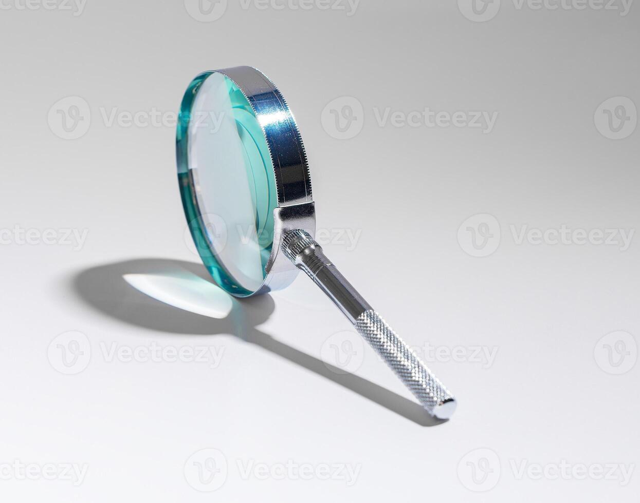 Office work with magnifying glass to inspect, analyze documents. Business analysis, data research, photo