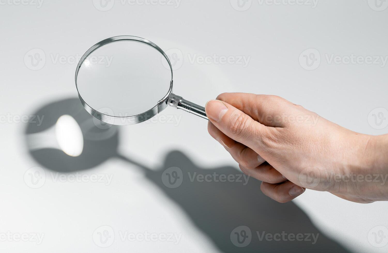 Woman using magnifying glass, searching, analyzing documents. Business research, detective work in photo