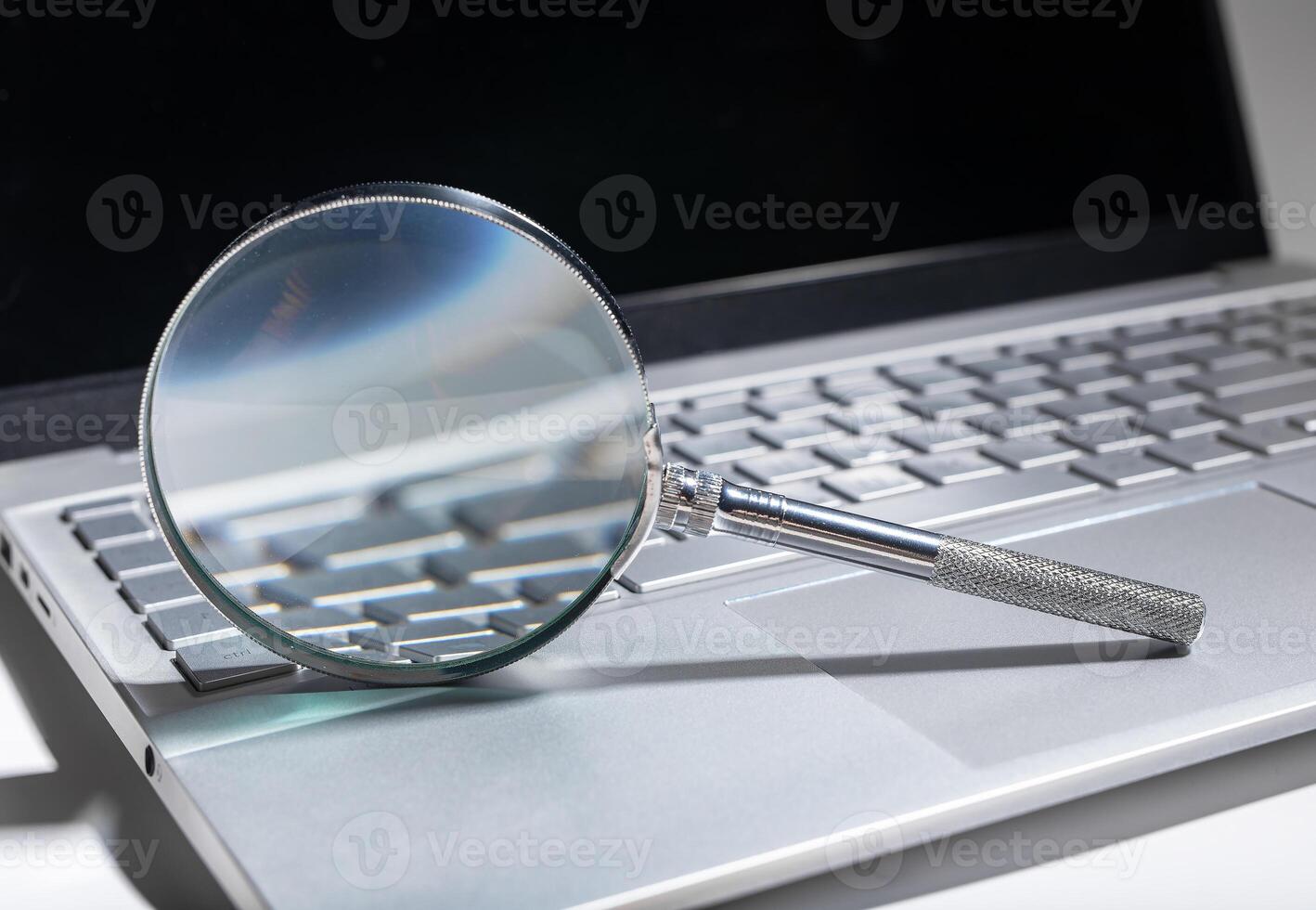 Investigation through technology, magnifying digital data on laptop. Business research, financial photo