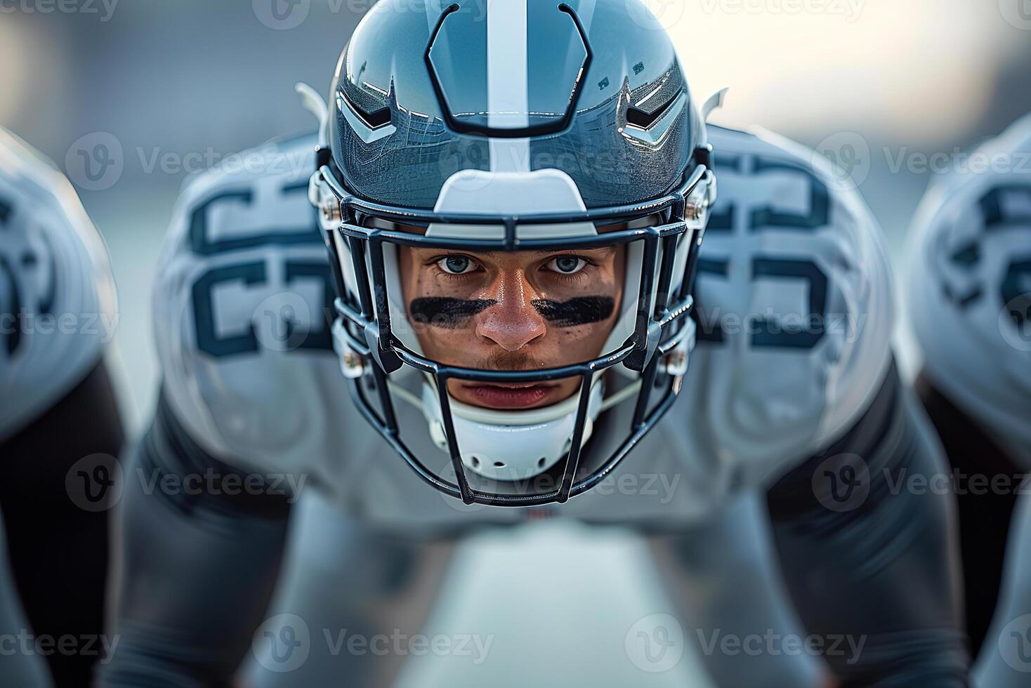 American football player in a gray helmet and white uniform stands waiting for the ball to be drawn photo