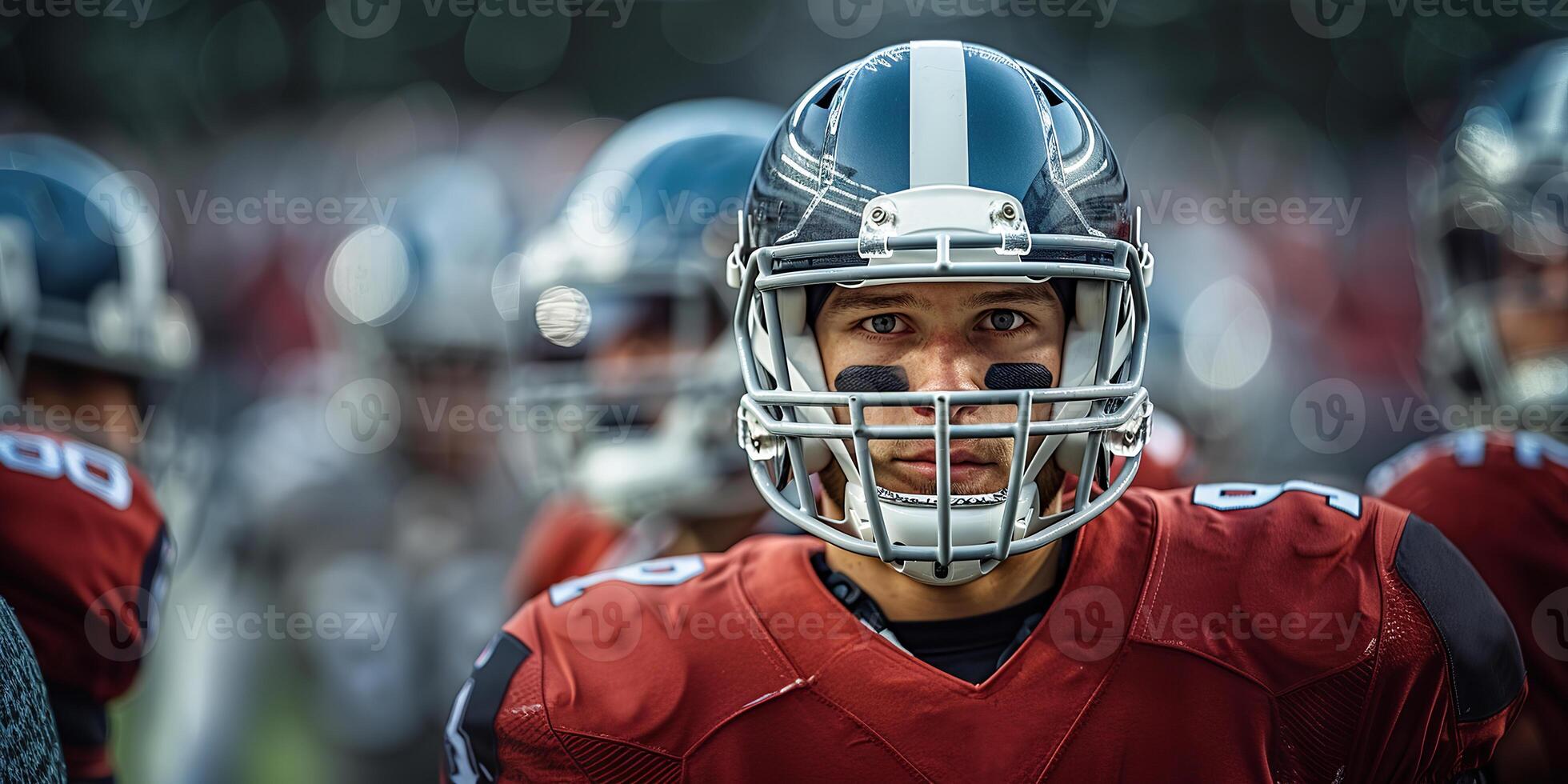 American football player in a black helmet and red uniform at a match next to the players of his team. Copy space photo