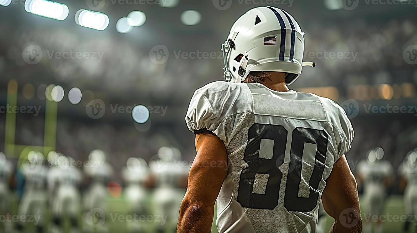 American football player in a white helmet and uniform stands with his back against the background of the players of his team and the stands of the arena. Copy space photo