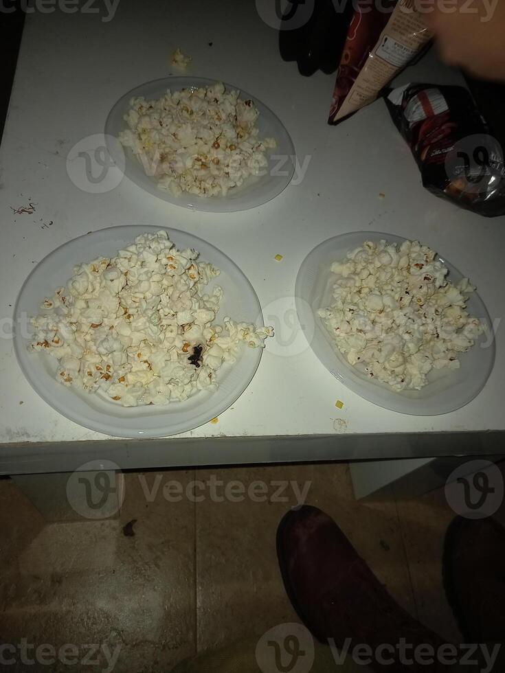 Popcorn in white plates on a white table photo