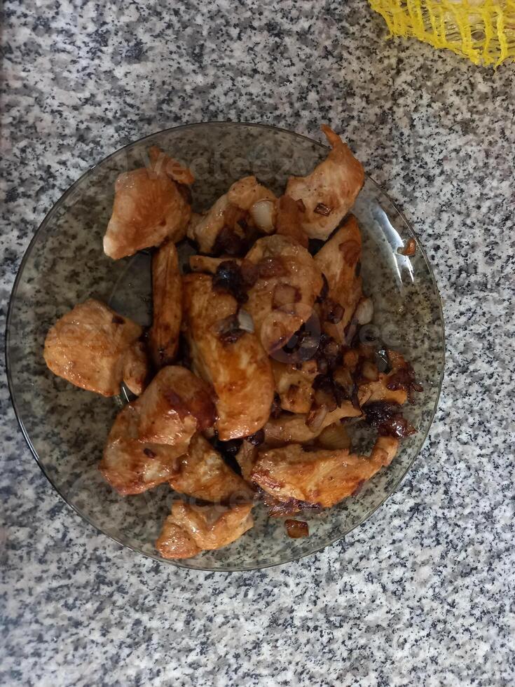 Fried Chinese chicken on a plate on a granite countertop photo
