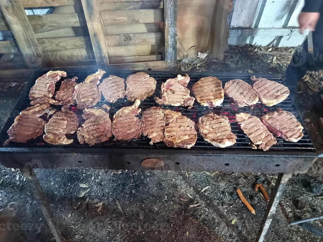 Steaks on a barbecue in the process of cooking photo
