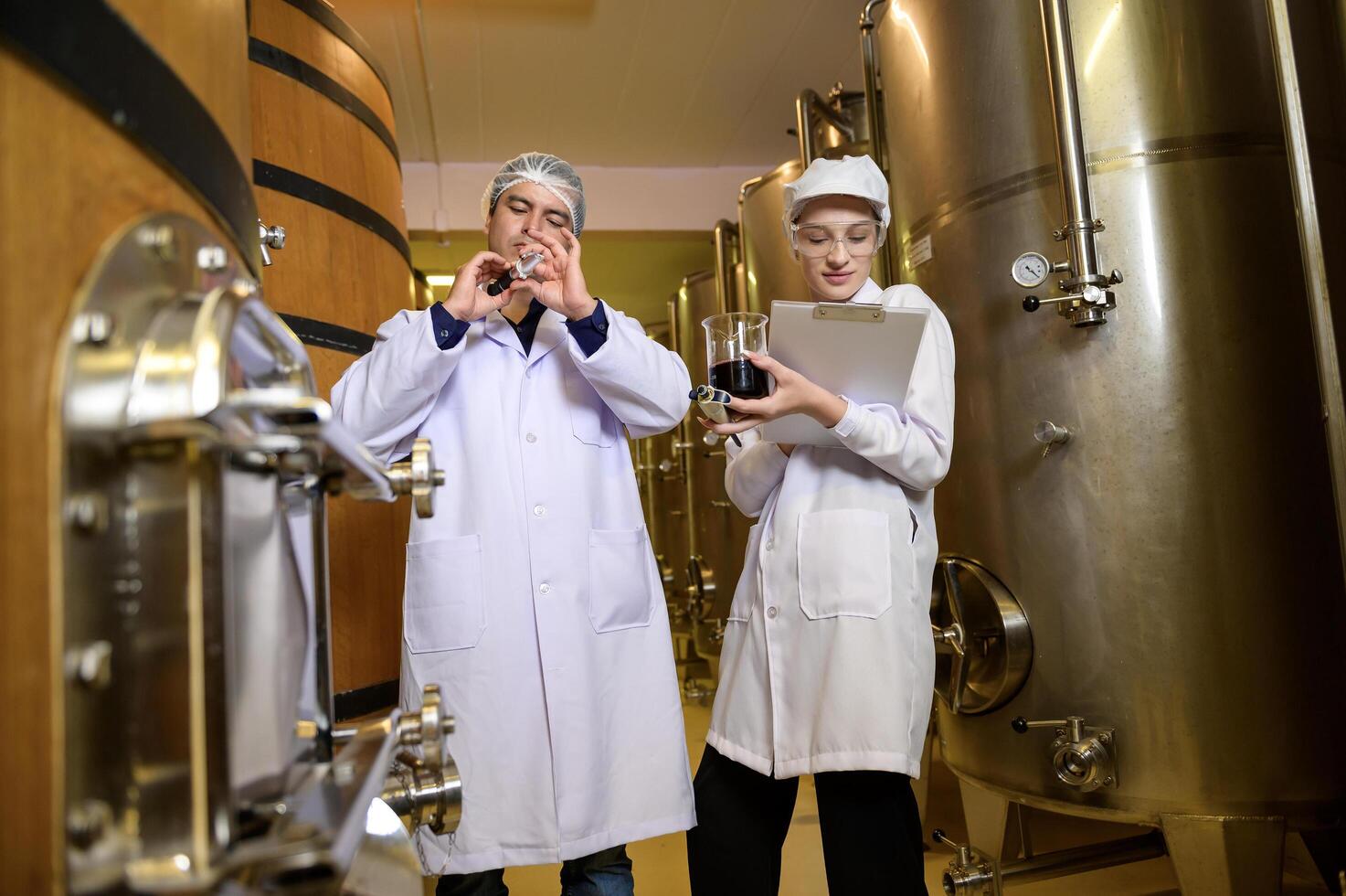 Professional winemaker controlling wine making process and quality at winery factory photo