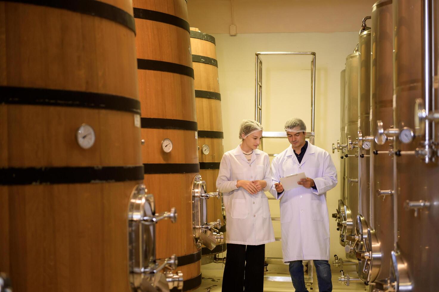 Professional winemaker controlling wine making process and quality at winery factory photo