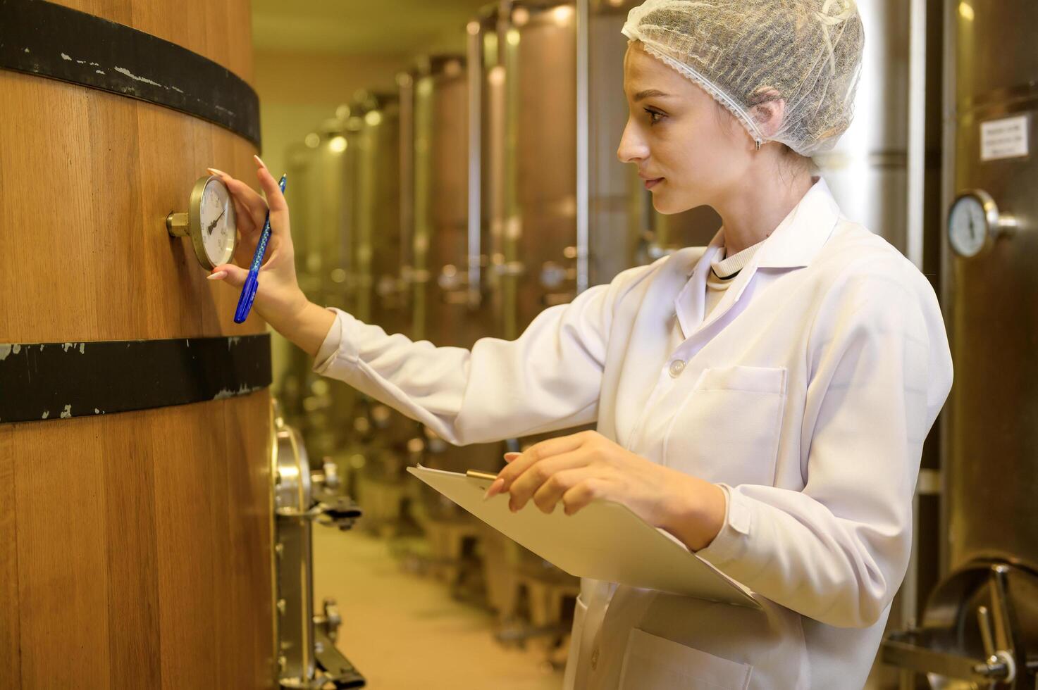 Professional winemaker controlling wine making process and quality at winery factory photo