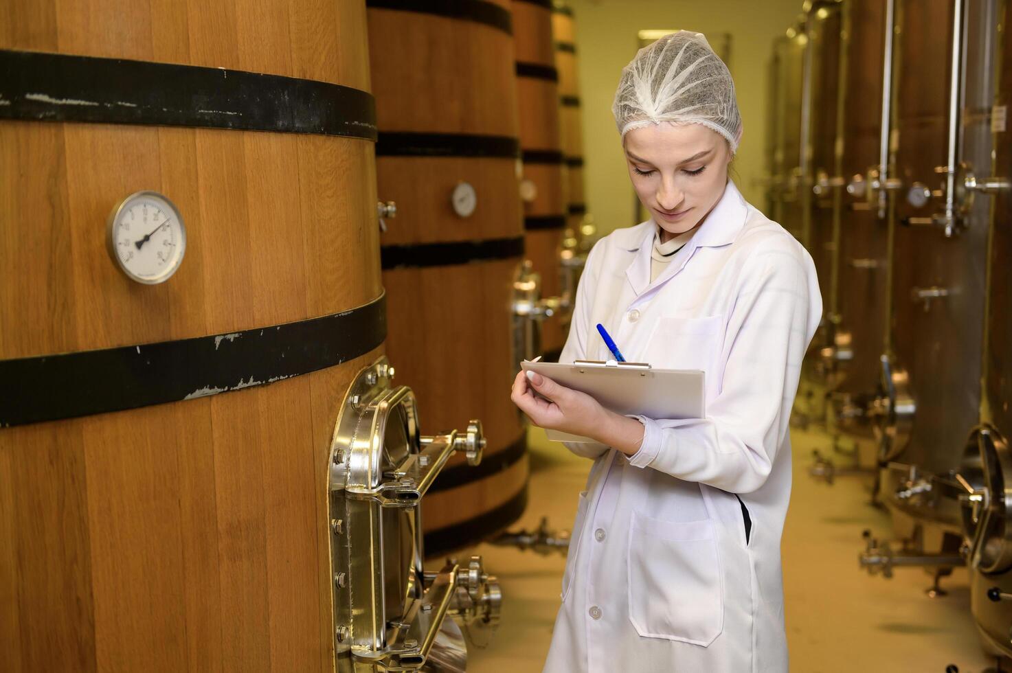 Professional winemaker controlling wine making process and quality at winery factory photo