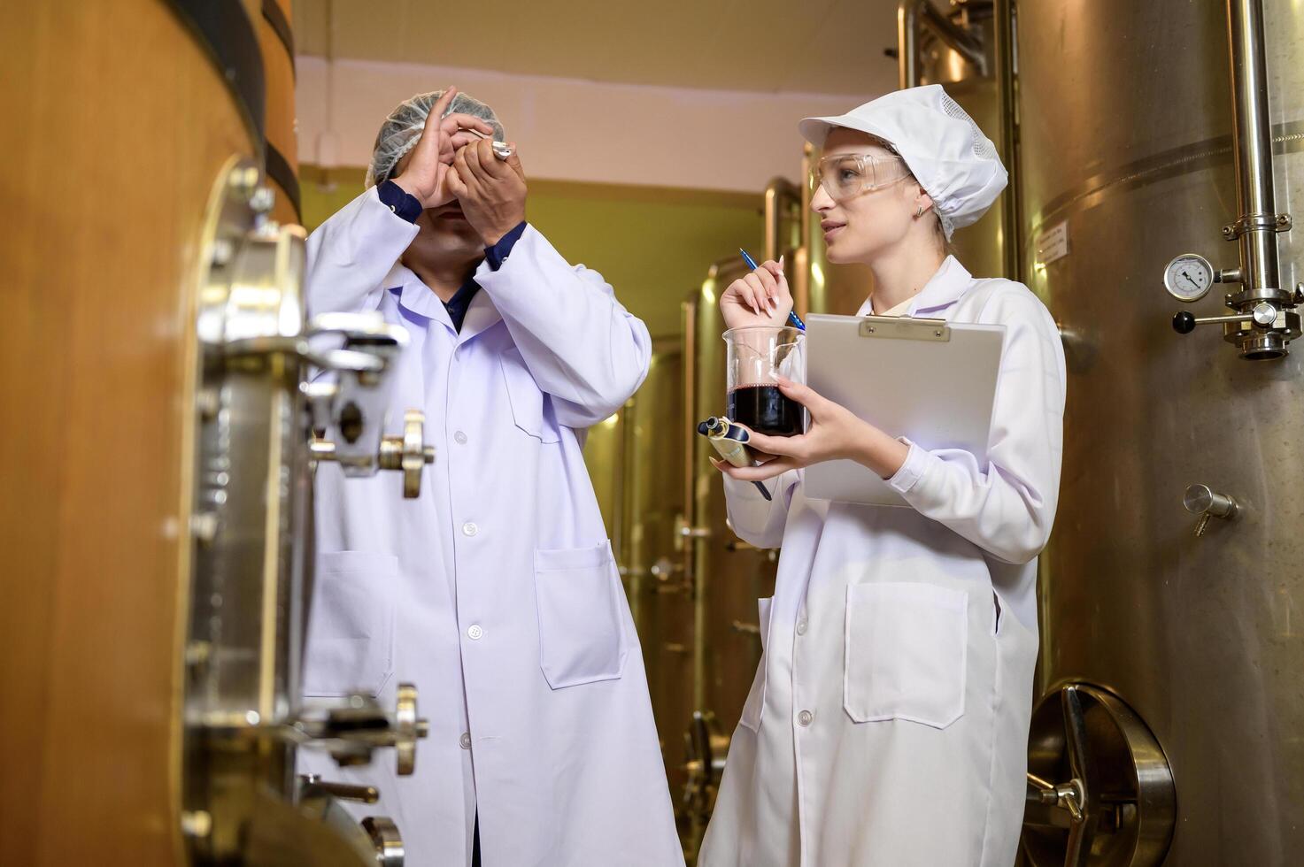 Professional winemaker controlling wine making process and quality at winery factory photo