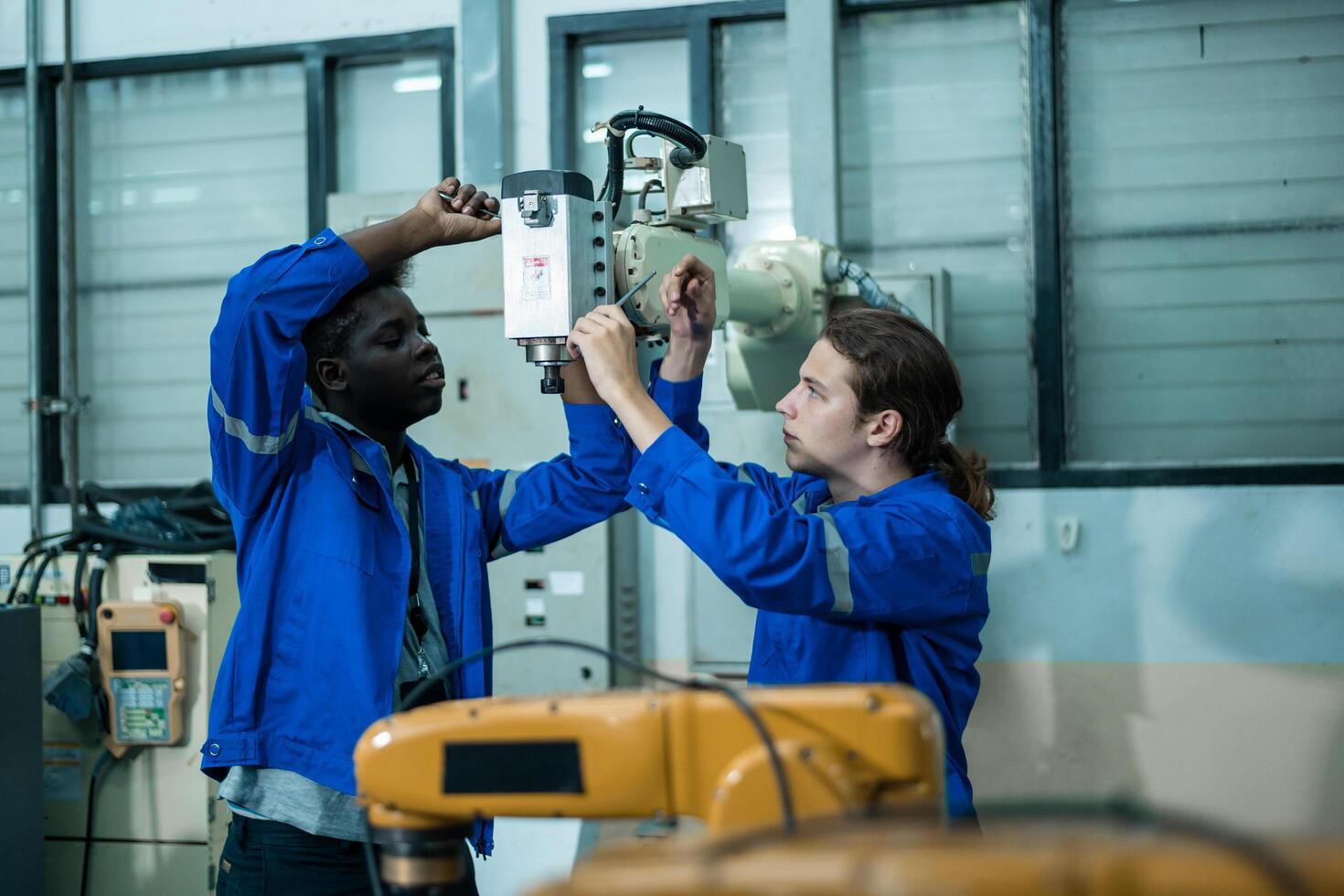 A group of Robotics engineers working with Programming and Manipulating Robot Hand, Industrial Robotics Design, High Tech Facility, Modern Machine Learning. Mass Production Automatics. photo