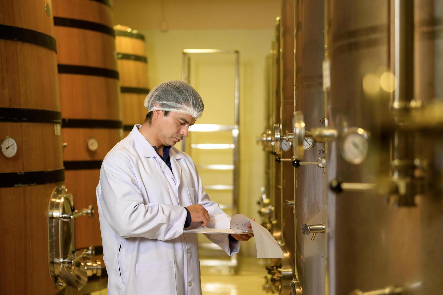Professional winemaker controlling wine making process and quality at winery factory photo