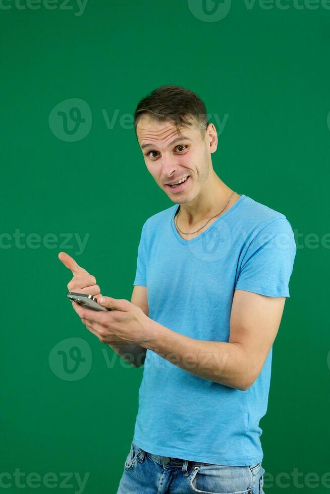 Young promoter man wear shirt white t-shirt point index finger camera on you indicate index finger aside on workspace area copy space mock up isolated on plain pastel green background studio photo