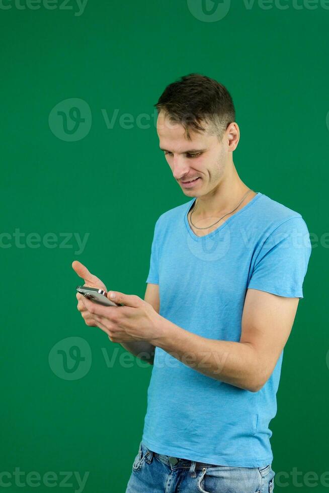 Young promoter man wear shirt white t-shirt point index finger camera on you indicate index finger aside on workspace area copy space mock up isolated on plain pastel green background studio photo