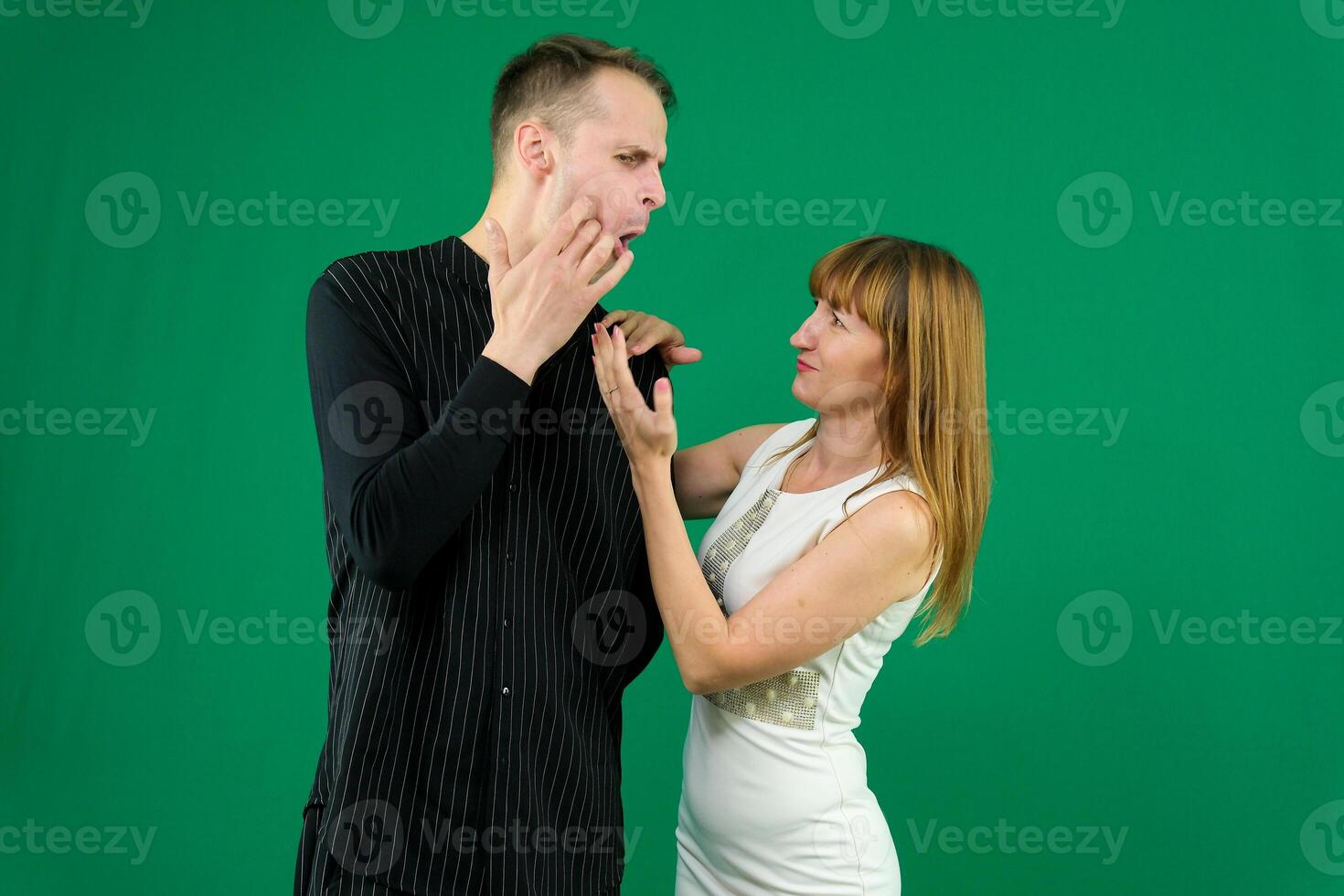 Beg squat look into the eyes stretch hands there desire to dance girl invites a man to dance on a green background makes eyes denim clothes chromakey bring time with me love relationship flirting photo